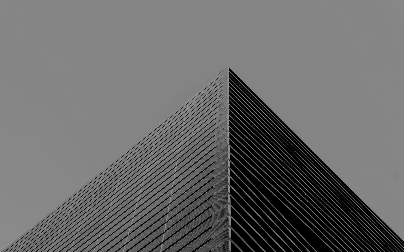 The apex of a tall building against a pale sky