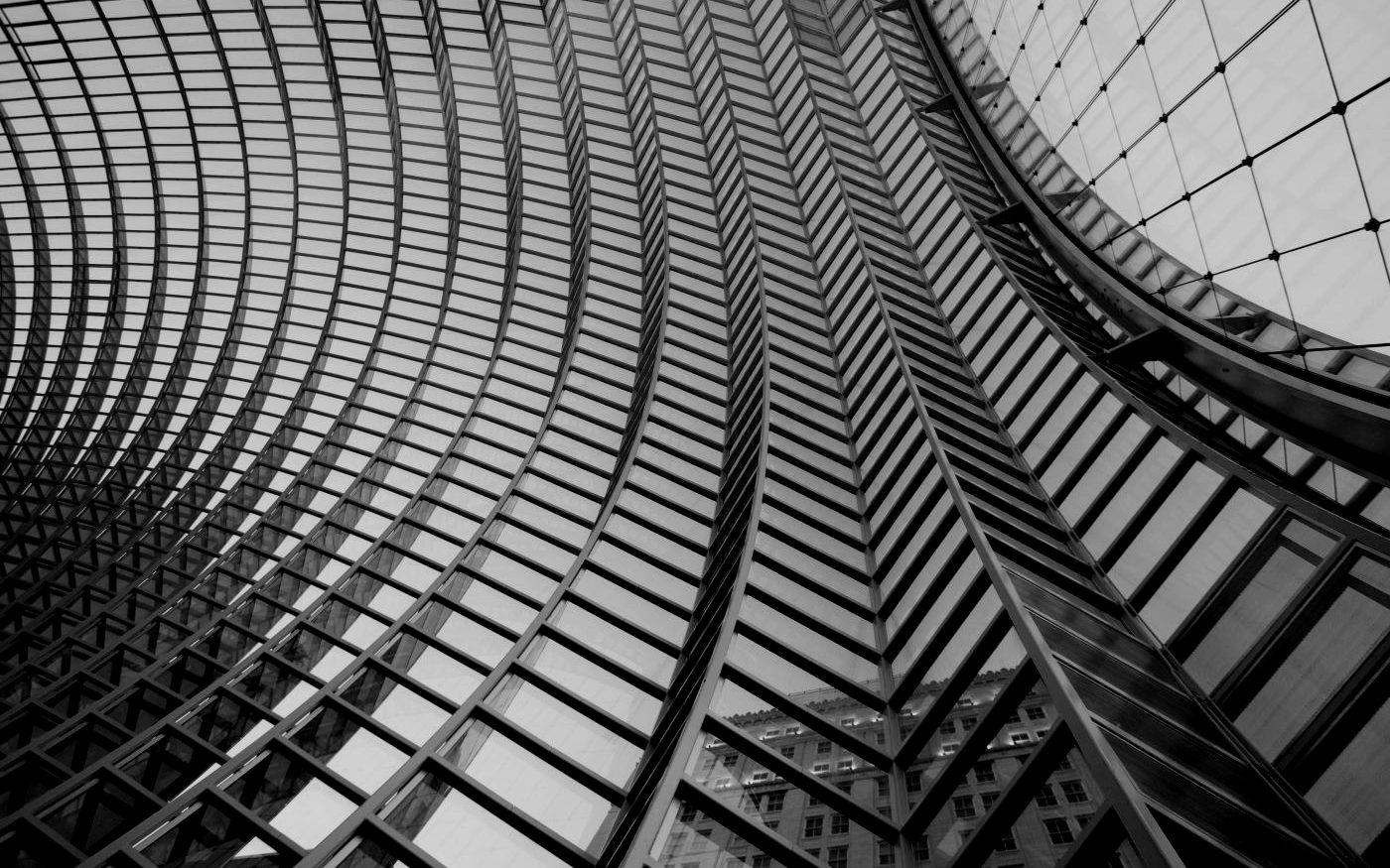 A curved glass atrium roof seen from below